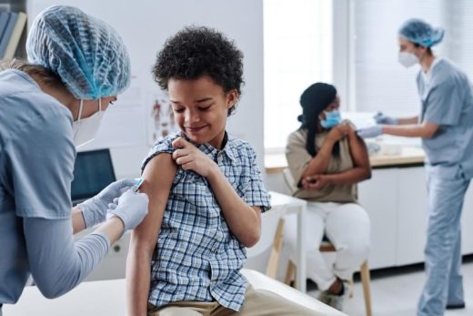 Niño es vacunado en el brazo por una enfermera