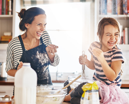 Madre e hija entre risas, realizan algunas recetas en la cocina de su casa